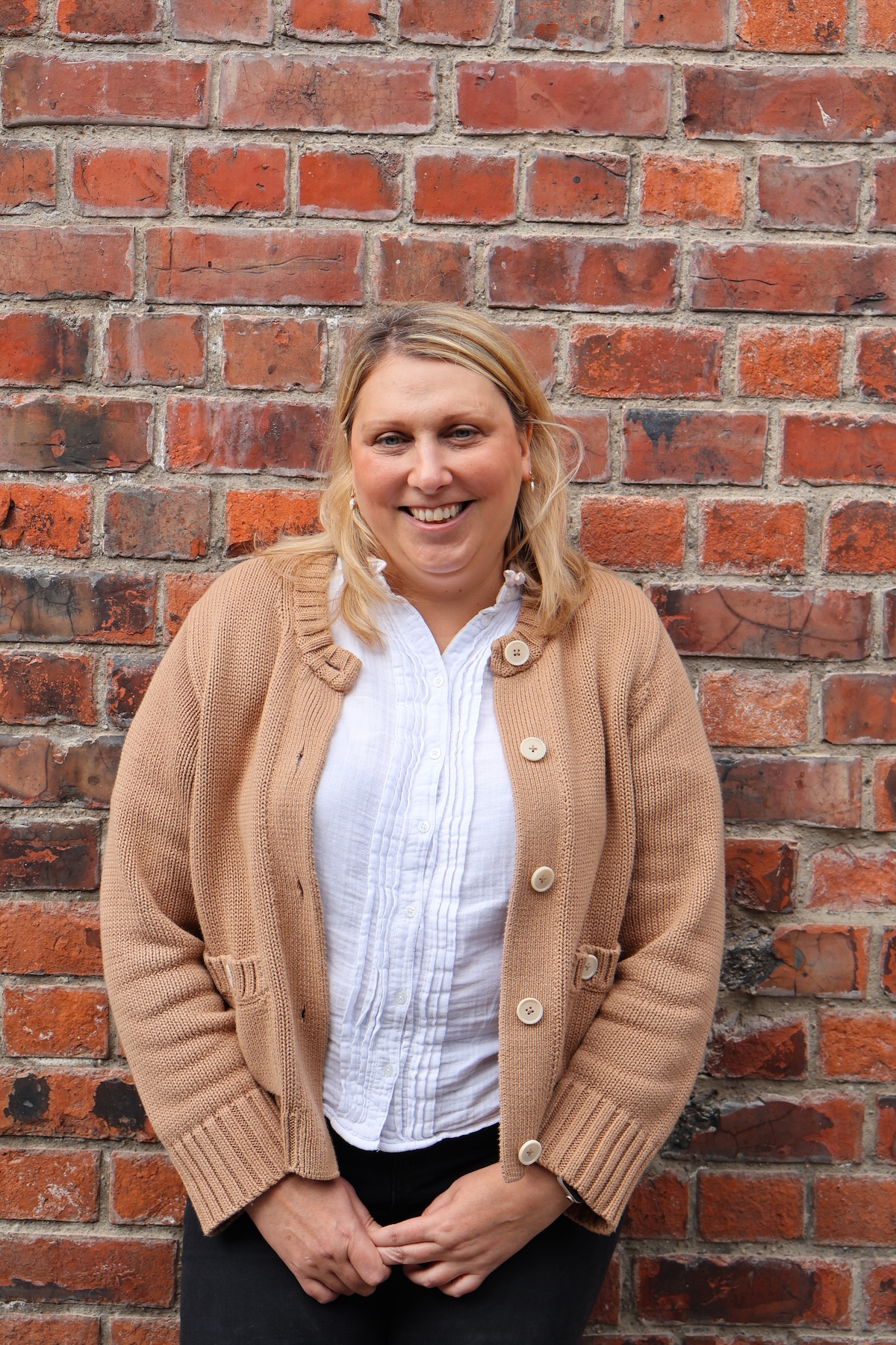 Sally stood in front of a brick wall